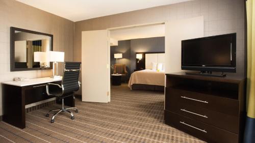 a hotel room with a television and a desk and a bed at Holiday Inn & Suites Mississauga West - Meadowvale by IHG in Mississauga
