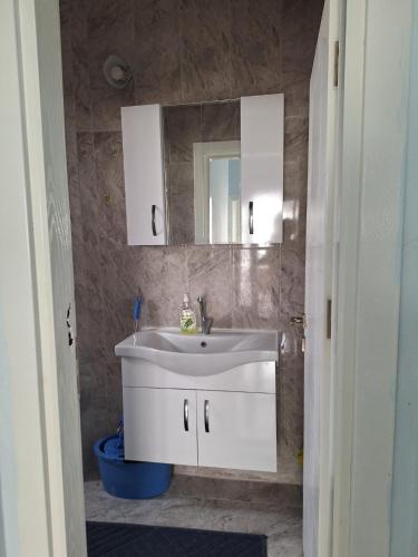 ein Badezimmer mit einem weißen Waschbecken und einem Spiegel in der Unterkunft Çakır villa in Silifke