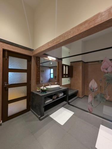 a bathroom with a sink and a large mirror at Nilayam by Luxunlock Private Villas in Jāmb