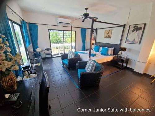 a hotel room with a bed and chairs and a room at The Venue Residence - SHA Extra Plus in Pattaya South