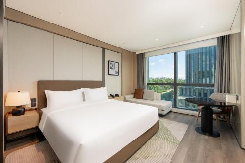 a bedroom with a large white bed and a desk at Holiday Inn Changchun High Tech Zone by IHG in Changchun