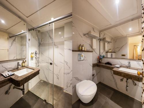 a bathroom with a toilet and two sinks and a shower at The Pinky Villa - Heritage Boutique Suites- New Delhi in New Delhi