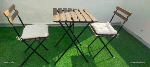 two chairs and a table with a bench on the grass at Loft El Til-ler in Bellvei del Penedes