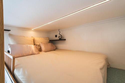 a small bedroom with a white bed with pillows at Cocon d Orion in Reims