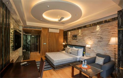 a living room with a bed and a couch at Jr Hotel Dharamshala in Dharamshala