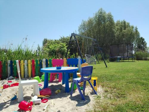 a table and chairs in the sand next to a playground at Apartamenty Mistral in Jastarnia