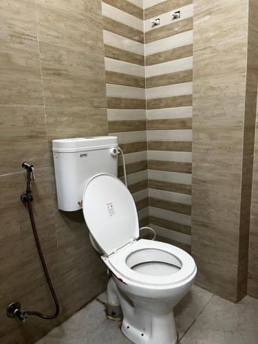 a bathroom with a white toilet in a room at Hotel Sun in Bishnupur