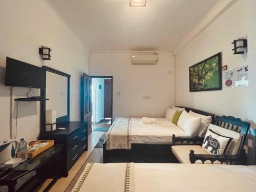 a hotel room with two beds and a mirror at The Heritage Inn in Kandy