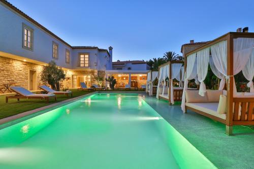a swimming pool with chairs and a house at Kose Konak Butik Hotel-Special in Alacati