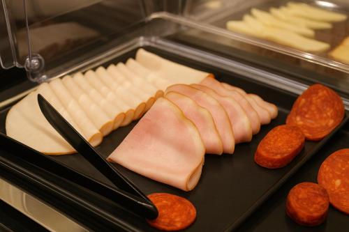 a tray with cheese and sausage and other meats at Hotel Ottofiori in Budapest