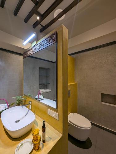 a bathroom with a sink and a toilet and a mirror at Nilayam by Luxunlock Private Villas in Jāmb