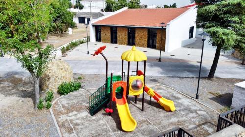 a playground with a slide in a yard at GlampINN Fuente Obejuna in Fuente Obejuna