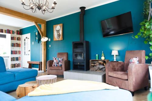 a living room with a fireplace and blue walls at Vakantiewoning buitenaf in Hellendoorn