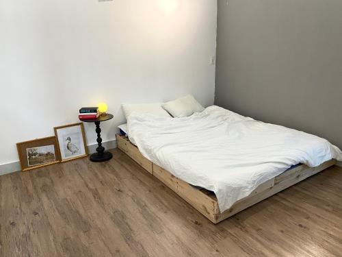 a bedroom with a bed with white sheets and a table at Anhbnb in Da Nang