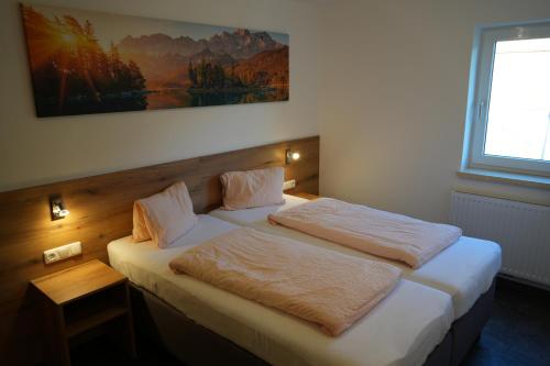 a bedroom with two beds and a painting on the wall at Ferienhaus Mott in Lermoos