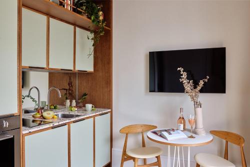 a kitchen with a small table with chairs and a sink at Turing Locke Cambridge in Cambridge