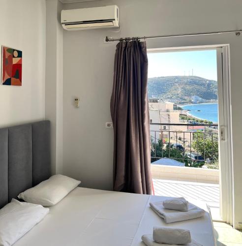 a bedroom with a bed and a window with a view at Duka Rooms in Himare
