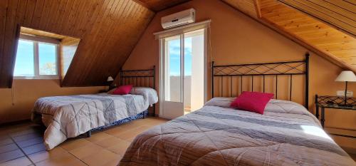 Un dormitorio con dos camas y una ventana. en Los Rosales De La Palmilla, en Montoro