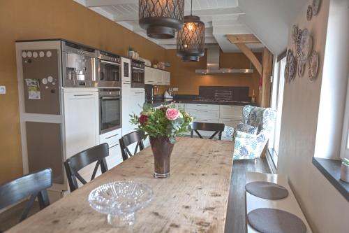 a kitchen with a table with a vase of flowers on it at Vakantiewoning buitenaf in Hellendoorn