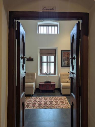 an open door to a living room with couches and a table at Nilayam by Luxunlock Private Villas in Jāmb