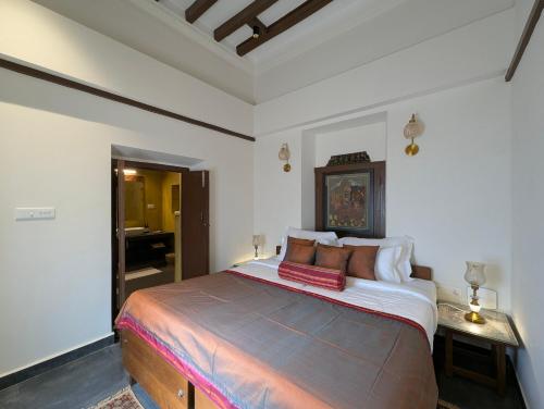 a bedroom with a large bed with pillows on it at Nilayam by Luxunlock Private Villas in Jāmb