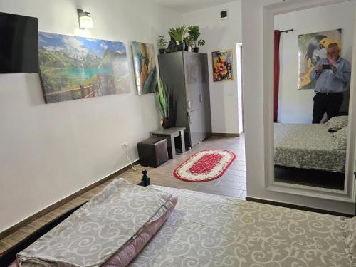 a bedroom with a bed and a man taking a picture in a mirror at Casa Rico 2 in Tulcea