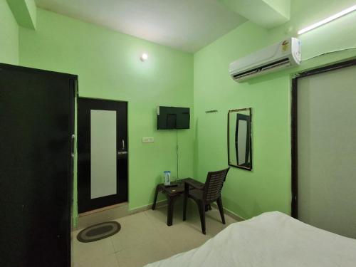 a green room with a table and a mirror at The Royal Inn in Jāmb