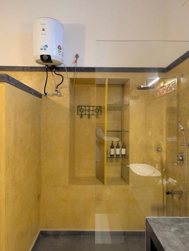 a bathroom with a shower with a camera on the wall at Nilayam by Luxunlock Private Villas in Jāmb