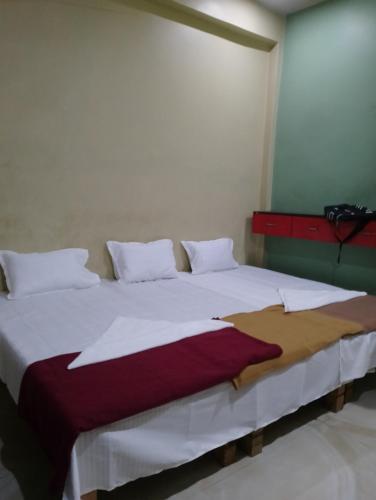 a bedroom with a large bed with white sheets at Shreeji niwas in Varanasi