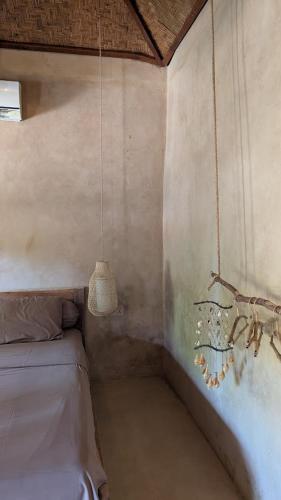 a small room with a bed and a lamp at The House of The Rising Tide in Mantaak