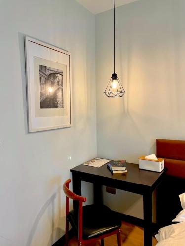 a room with a desk with a chair and a lamp at C U Inn Bangkok in Bangkok