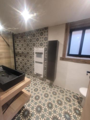 a room with a bathroom with a sink and a floor at Ti Ana Chambre Bohème in Évran