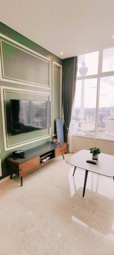 a living room with a large television and a table at Sky Suites KLCC by TD Luxe Global in Kuala Lumpur