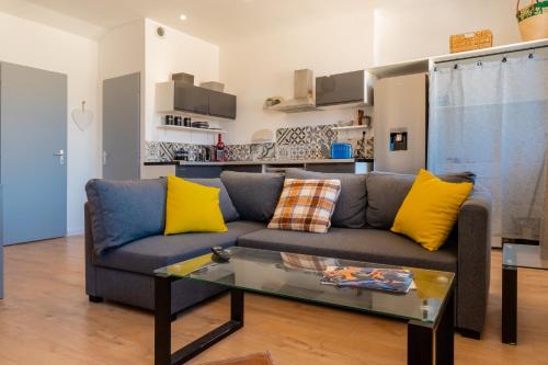 un soggiorno con un divano e un tavolo di TIKAZ Béziers - Appartement - 2 Chambres Hyper Centre a Béziers