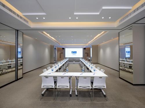 a large conference room with a long table and white chairs at Holiday Inn Express Zhuhai Grand Theater by IHG in Zhuhai
