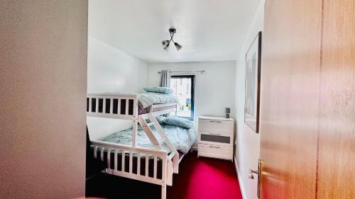 a small room with two bunk beds in it at Ground Floor Beach Front Apartment in Swansea