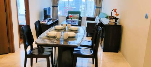 a dining room with a table and chairs and a window at Sky Suites KLCC by TD Luxe Global in Kuala Lumpur