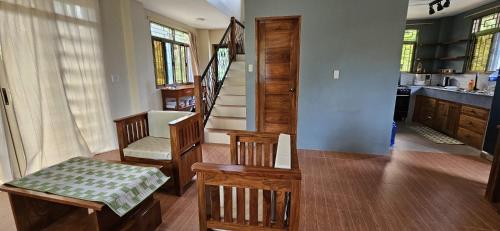 a living room with stairs and a table and chairs at Island Nest in Virac