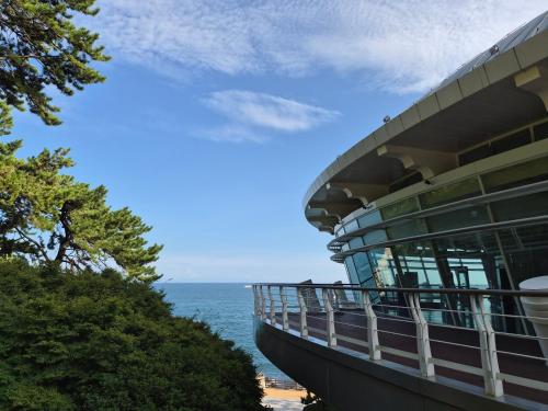 a building on the beach with the ocean in the background at Haeundae HaeRium Hotel in Busan