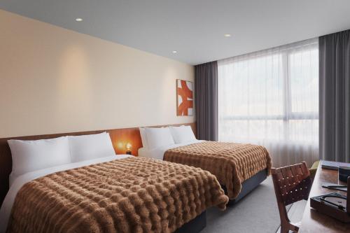 a hotel room with two beds and a window at HYATT - EPISODE Daan Taipei, jdv by Hyatt in Taipei