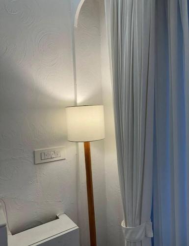 a lamp in a bathroom next to a white curtain at Azure Luxury 2Bhk in Candolim
