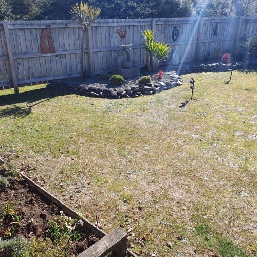 a backyard with a fence and a garden at Moe Marie Sleep Peacefully in Turangi