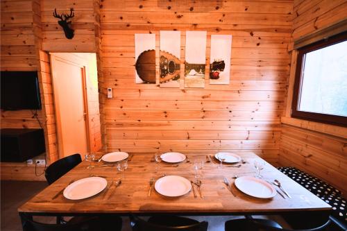 a dining room with a table with plates and wine glasses at Chalet Mandoline in Petit Mesnil