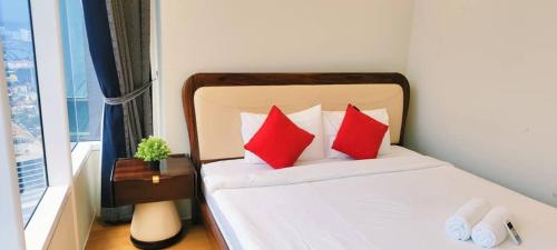 a bedroom with a bed with red pillows and a window at Sky Suites KLCC by TD Luxe Global in Kuala Lumpur
