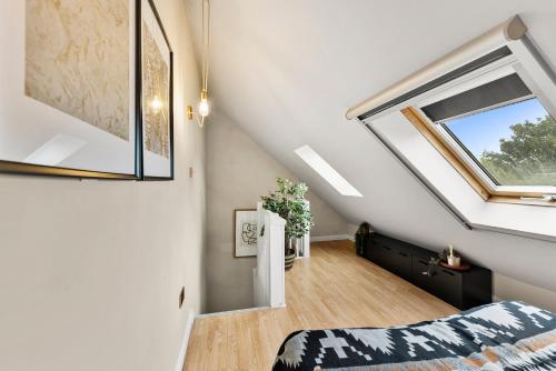 a attic bedroom with a window and a bed at Beautiful House in Cambridge - Sleeps 6 in Milton