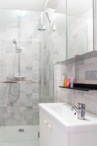 a white bathroom with a sink and a shower at Joli Appartement - 2 Chambres - Allées Paul Riquet in Béziers