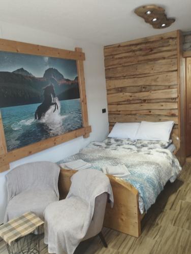 une chambre avec un lit et deux chaises dans l'établissement Apartman Andjeo, à Žabljak