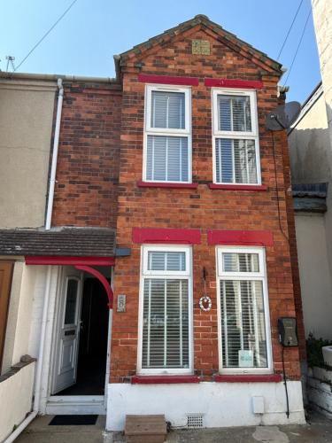 a brick house with white windows and a door at “The Reach” Lovely 2 bed house in Gorleston on Sea in Gorleston-on-Sea