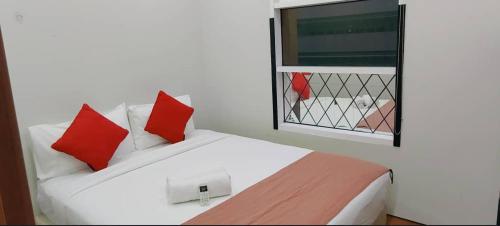 a bedroom with a bed with red pillows and a window at Sky Suites KLCC by TD Luxe Global in Kuala Lumpur