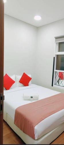 a bedroom with a large white bed with red pillows at Sky Suites KLCC by TD Luxe Global in Kuala Lumpur